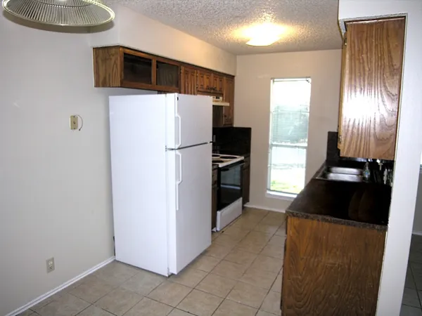 a kitchen with a refrigerator and a more cabinets
