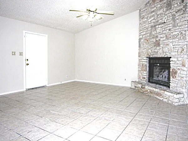 a view of an empty room with window and fire place