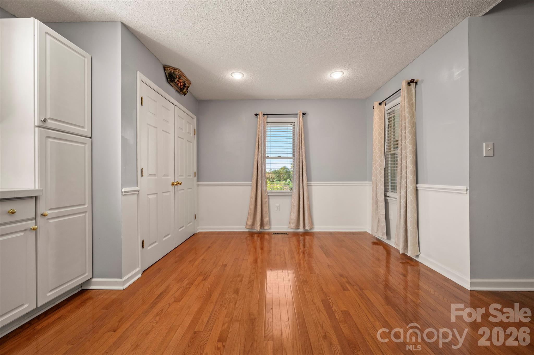 506 Pleasant Street Spindale, NC 28160 - Photo 12 of 42 an empty room with wooden floor and windows