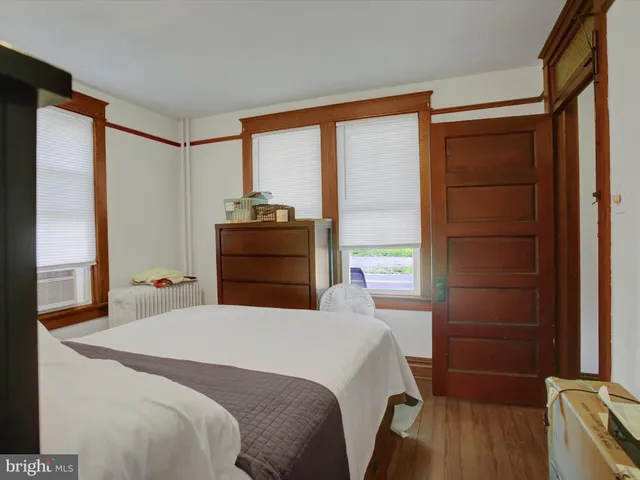 a bedroom with a bed and a dresser next to a window