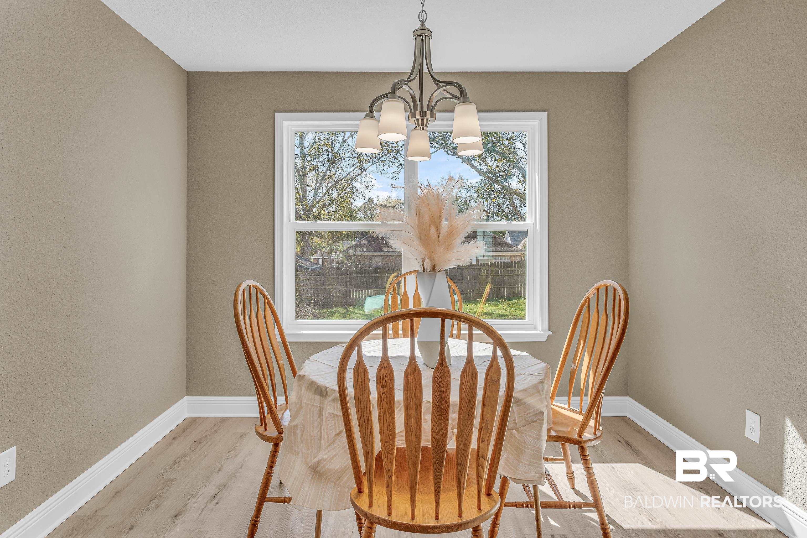 9206 Greenleaf Drive Daphne, AL 36527 - Photo 12 of 32 Dining room with light wood-style flooring, a textured wall, and a chandelier