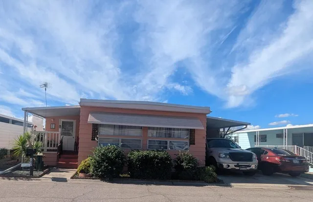 a front view of a house with cars parked