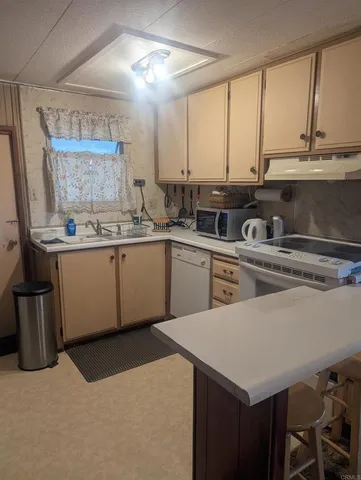 a kitchen with a sink a stove and cabinets