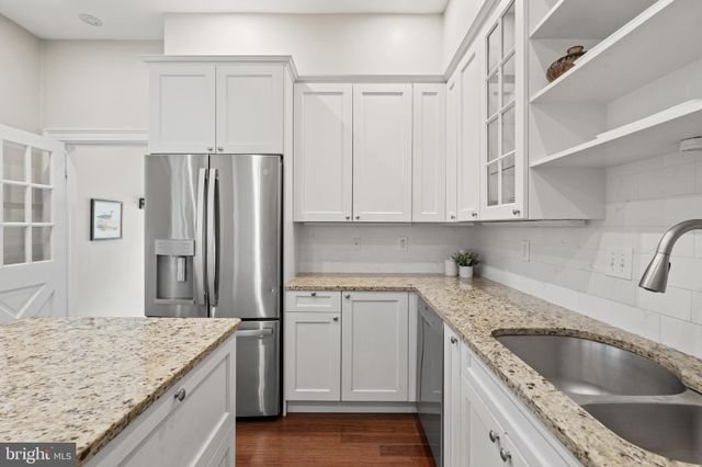 a kitchen with granite countertop a sink stove and refrigerator
