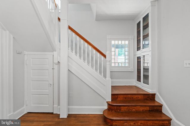 a view of staircase with lots of frames on wall and wooden floor