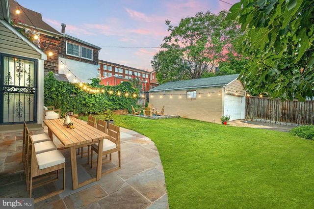 a patio with table and chairs and potted plants