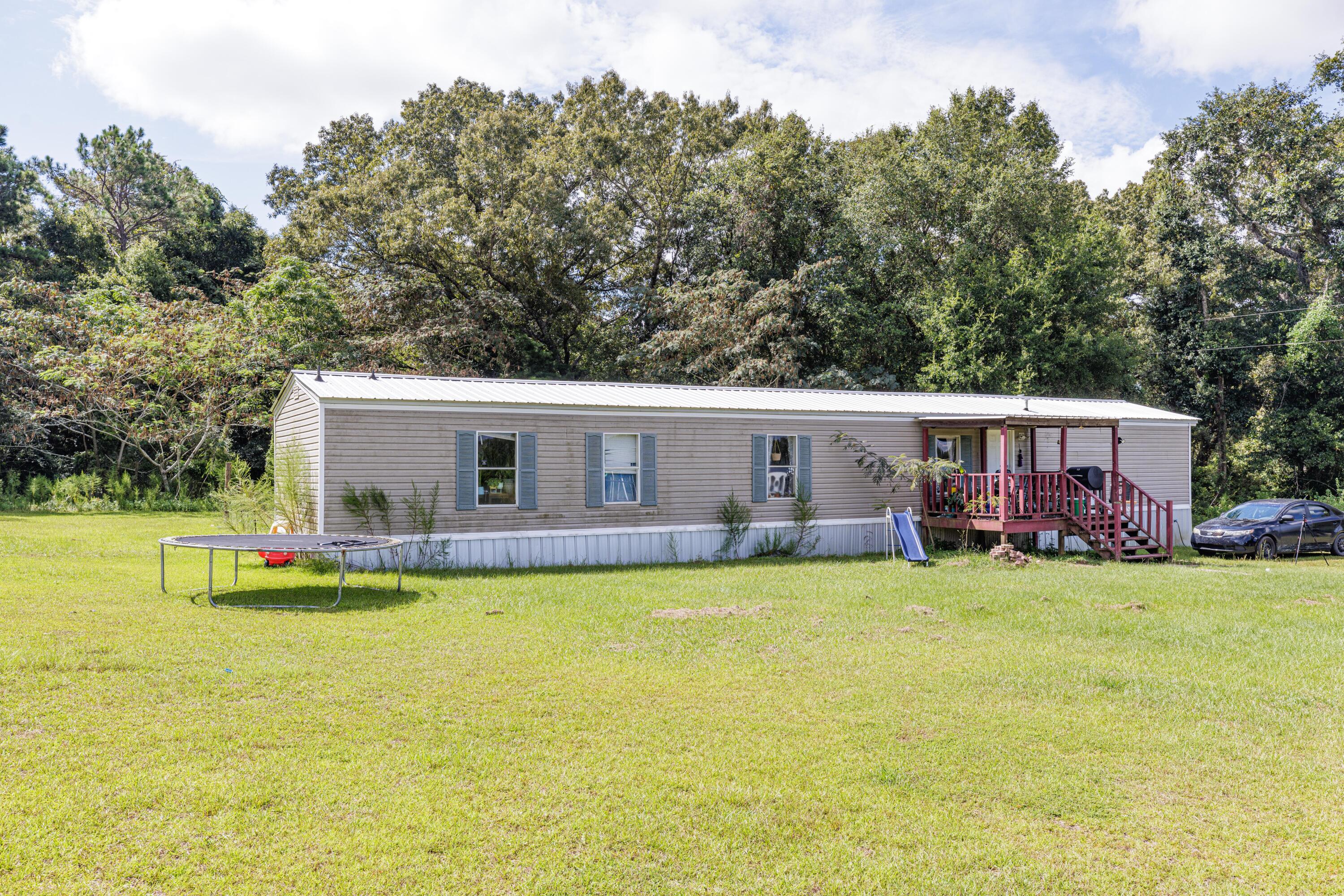 6337 Sherman Kennedy Road Baker, FL 32531 - Photo 4 of 17 a view of a house with swimming pool and a garden