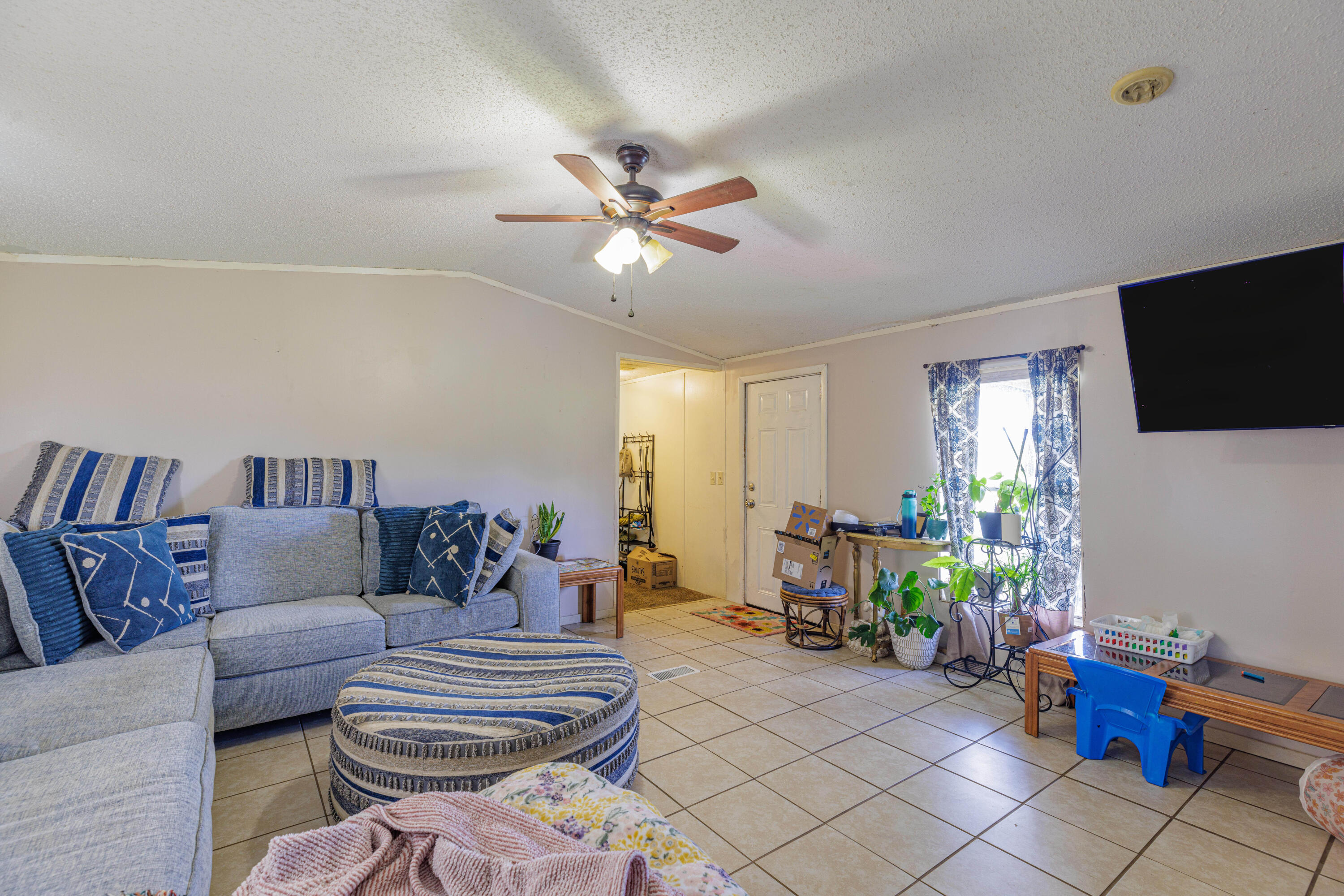 6337 Sherman Kennedy Road Baker, FL 32531 - Photo 6 of 17 a living room with furniture a flat screen tv and a window