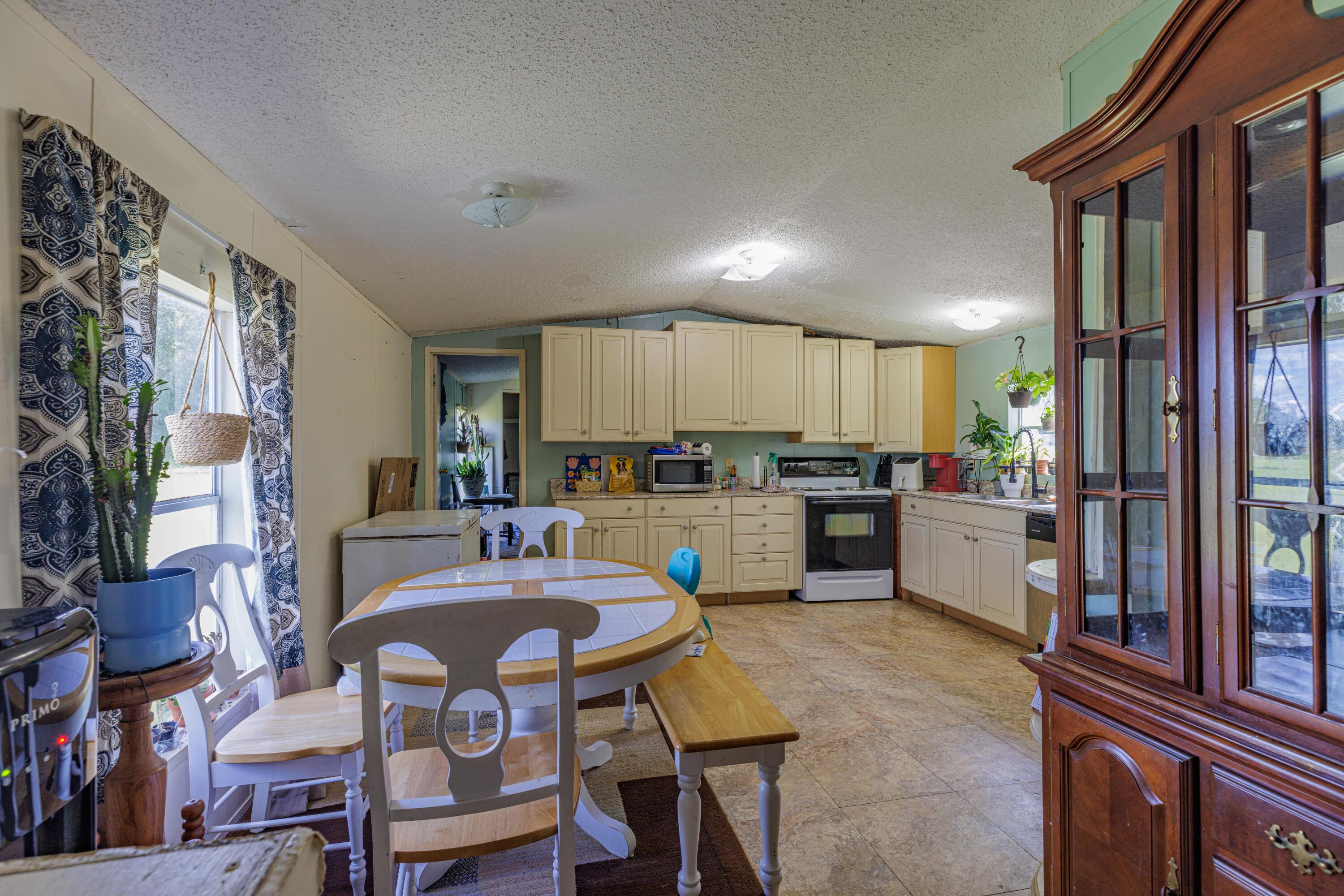 6337 Sherman Kennedy Road Baker, FL 32531 - Photo 9 of 17 a kitchen with granite countertop a refrigerator and cabinets