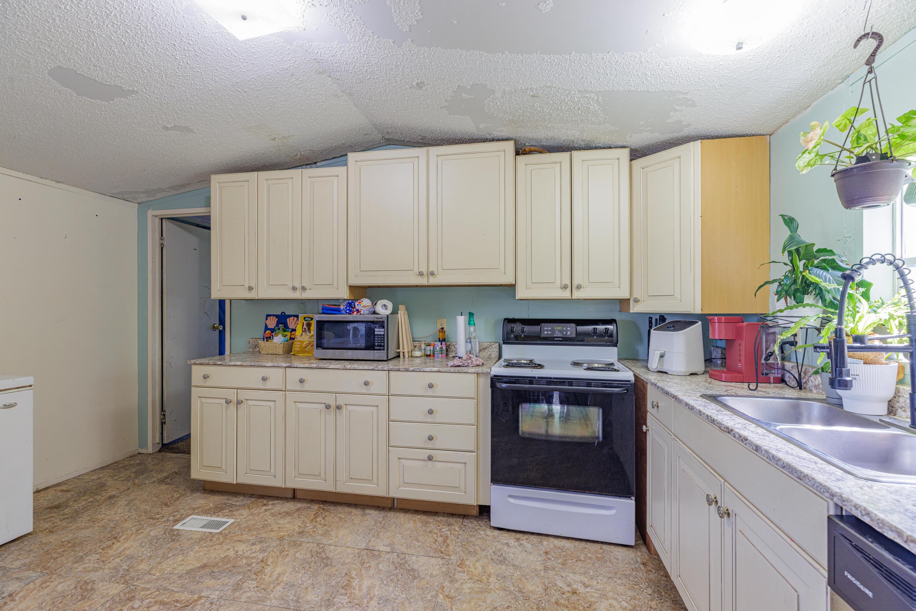 6337 Sherman Kennedy Road Baker, FL 32531 - Photo 10 of 17 a kitchen with white cabinets and white appliances