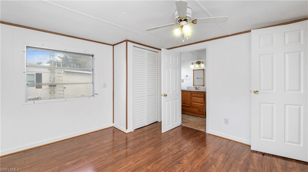 171 Grassy Key Lane Naples, FL 34114 - Photo 11 of 25 an empty room with wooden floor cabinet and windows