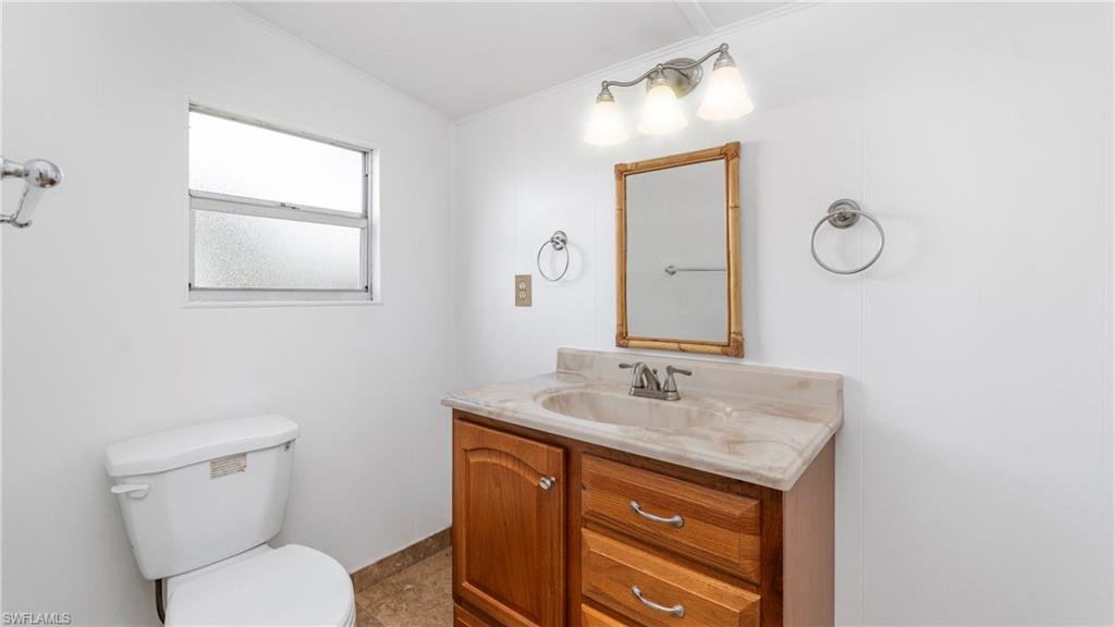 171 Grassy Key Lane Naples, FL 34114 - Photo 12 of 25 a bathroom with a toilet sink vanity and mirror