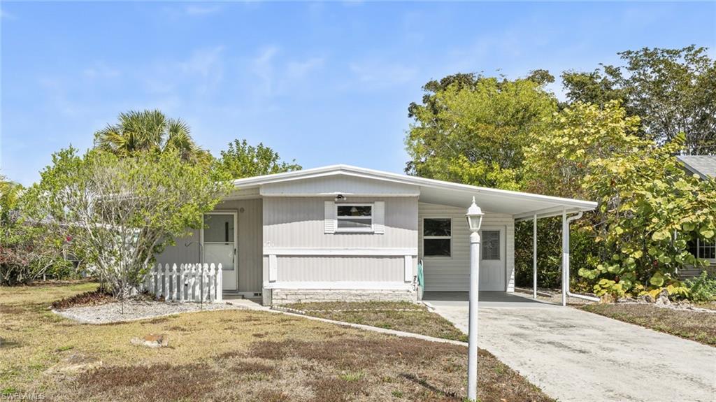 171 Grassy Key Lane Naples, FL 34114 - Photo 19 of 25 a front view of a house with a garden