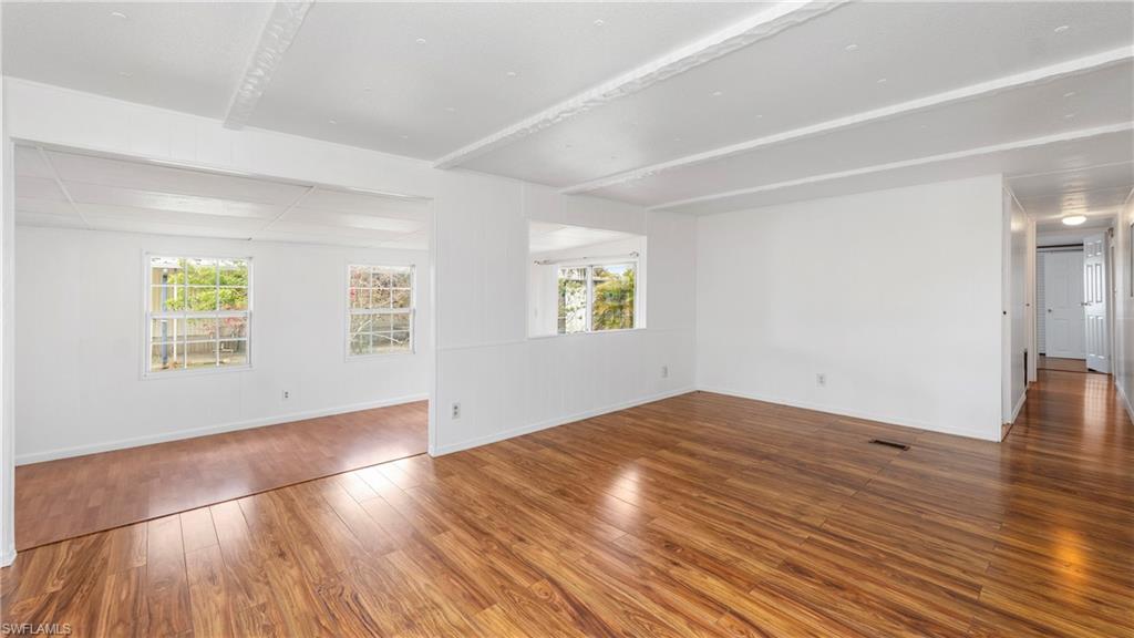 171 Grassy Key Lane Naples, FL 34114 - Photo 6 of 25 an empty room with wooden floor and windows
