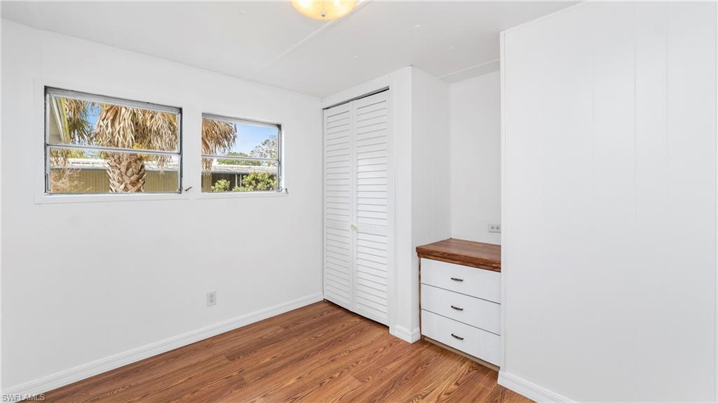 171 Grassy Key Lane Naples, FL 34114 - Photo 7 of 25 a view of an empty room with a window and wooden floor