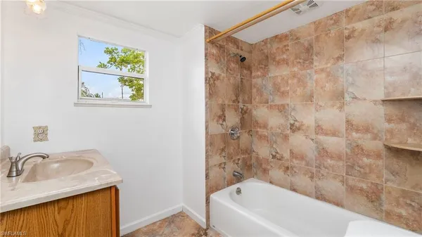 a bathroom with a sink a bathtub and a window