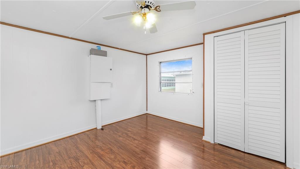 171 Grassy Key Lane Naples, FL 34114 - Photo 10 of 25 an empty room with wooden floor closet and windows