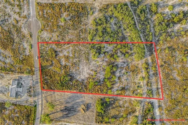 a view of a wooden house with a yard and potted plants