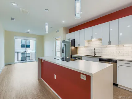 a kitchen with stainless steel appliances granite countertop a sink a stove and refrigerator