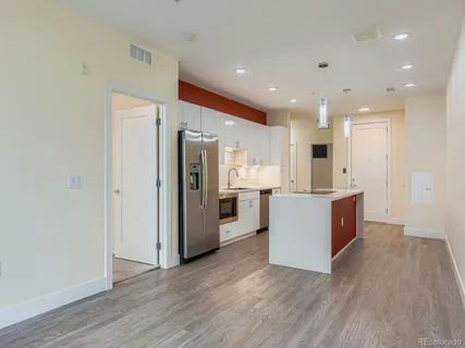 a large kitchen with a center island wooden floor stainless steel appliances and windows