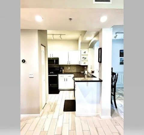 a kitchen with stainless steel appliances kitchen island granite countertop a refrigerator and a stove top oven