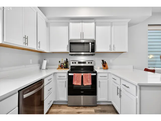 a kitchen with stainless steel appliances granite countertop a stove a sink and a microwave