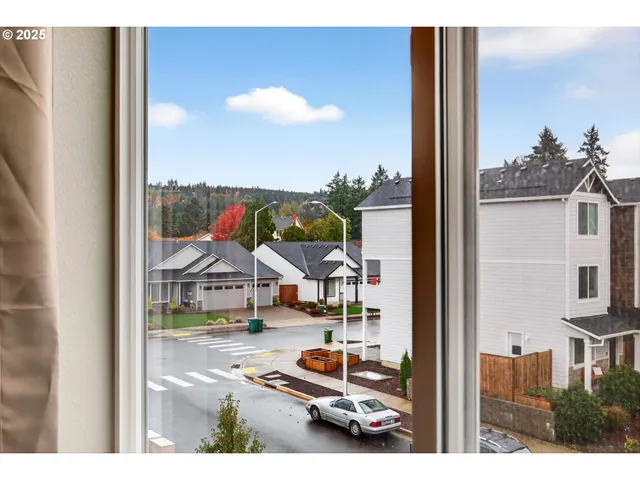a balcony view with couple of cars parked on the roadside