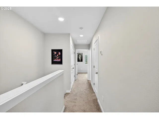 a hallway with white walls and wooden floor