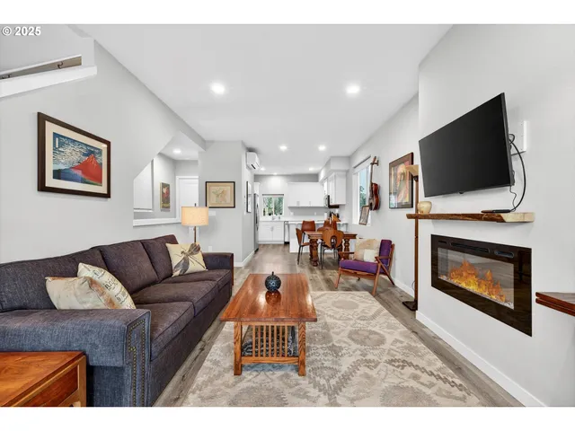 a living room with furniture a flat screen tv and a fireplace