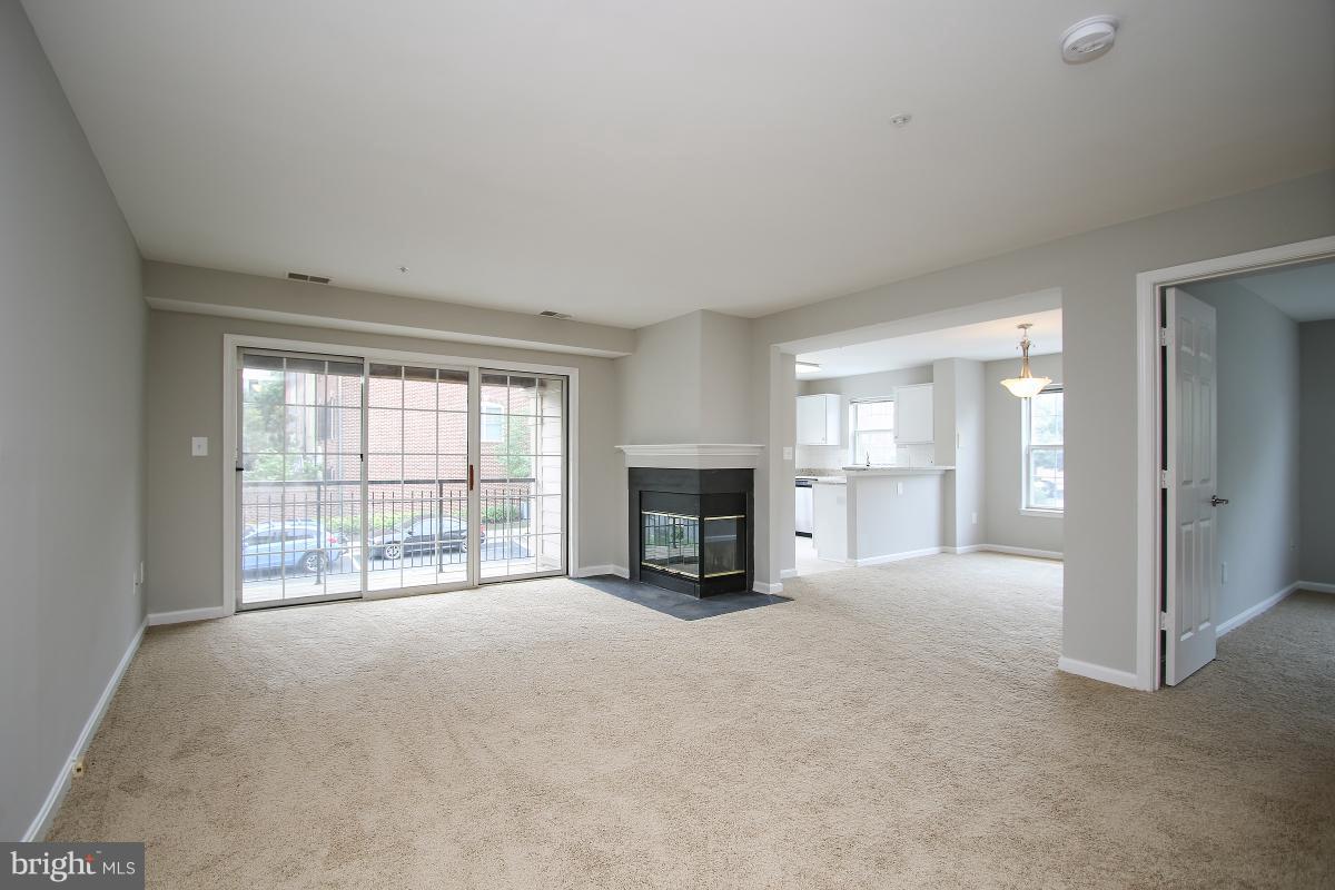 a view of an empty room with a fireplace and a window