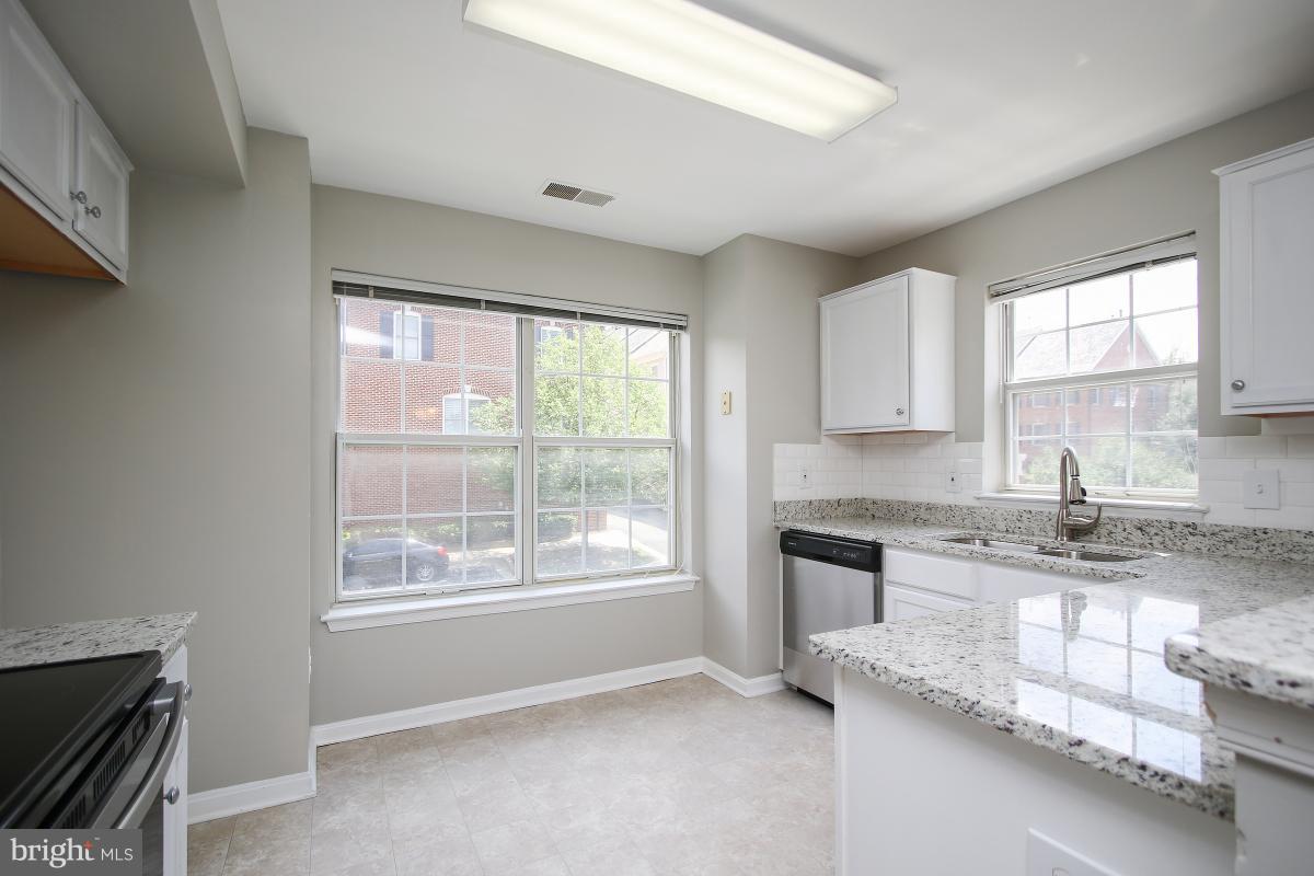 402 Ridgepoint Place, Unit 28 Gaithersburg, MD 20878 - Photo 2 of 29 a kitchen with granite countertop a sink appliances cabinets and a counter top space