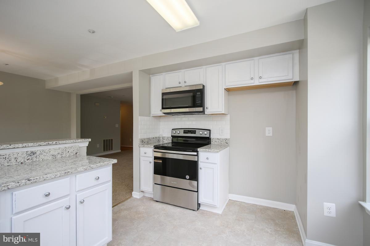 402 Ridgepoint Place, Unit 28 Gaithersburg, MD 20878 - Photo 11 of 29 a kitchen with granite countertop a stove and a sink