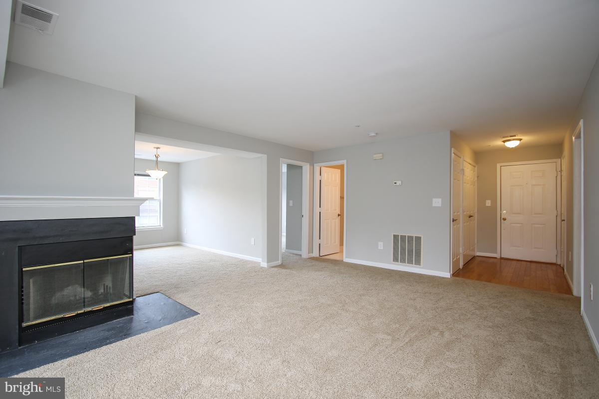402 Ridgepoint Place, Unit 28 Gaithersburg, MD 20878 - Photo 3 of 29 a view of an empty room with a fireplace and a window