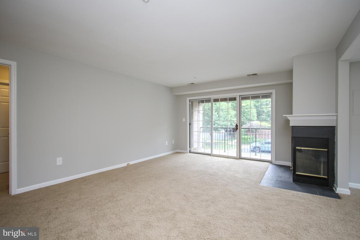 402 Ridgepoint Place, Unit 28 Gaithersburg, MD 20878 - Photo 5 of 29 an empty room with fireplace and a window