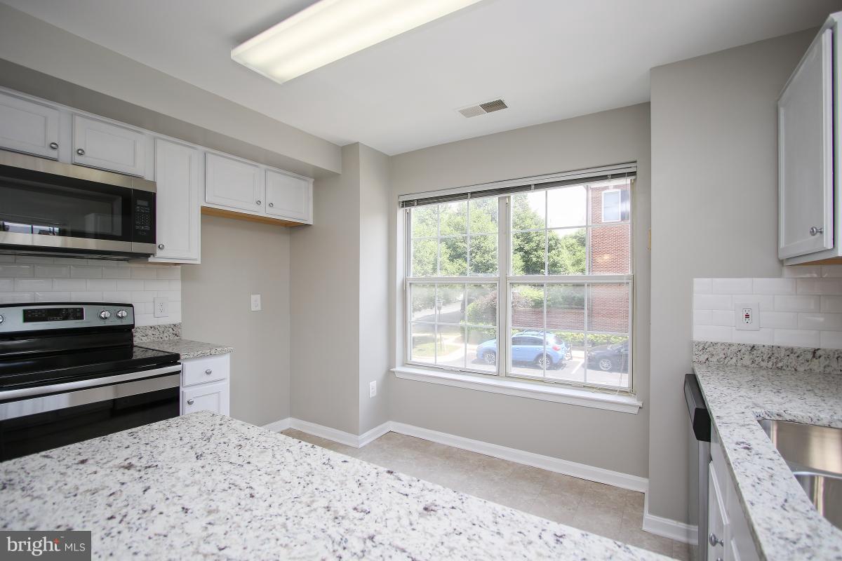 402 Ridgepoint Place, Unit 28 Gaithersburg, MD 20878 - Photo 9 of 29 a kitchen with a stove a sink and a microwave