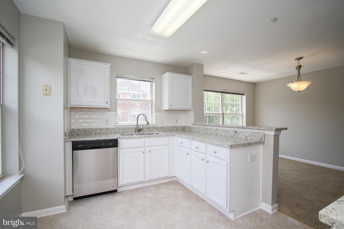 402 Ridgepoint Place, Unit 28 Gaithersburg, MD 20878 - Photo 10 of 29 a kitchen with granite countertop white cabinets and a sink