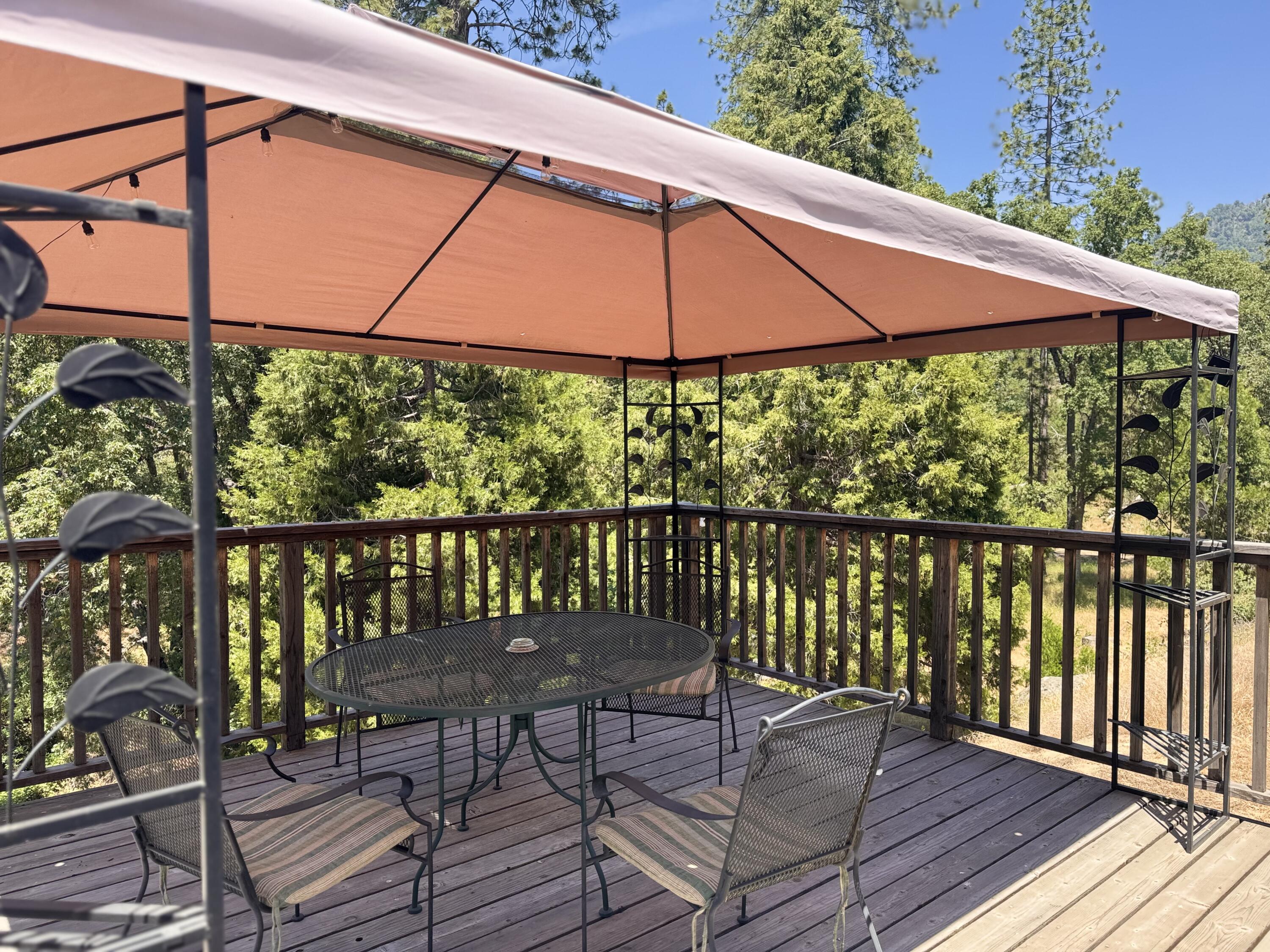 51911 Hogback Miramonte, CA 93641 - Photo 21 of 49 a view of a balcony with table and chairs under an umbrella