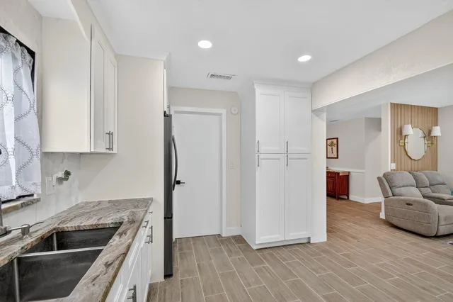 a kitchen with stainless steel appliances granite countertop a refrigerator and a sink