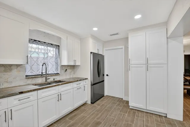a kitchen with stainless steel appliances granite countertop a refrigerator and a sink