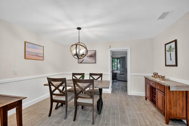 a view of a dining room with furniture wooden floor and chandelier