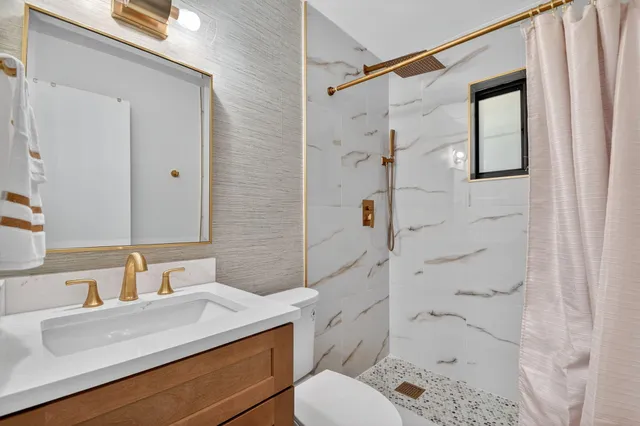 a bathroom with a sink toilet and shower