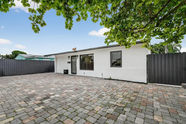 a view of a house with a backyard and a tree