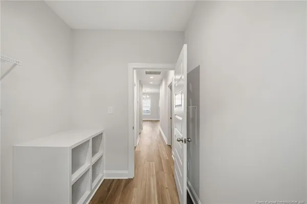 a view of a hallway with wooden floor and closet