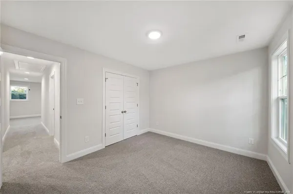 an empty room with windows and closet