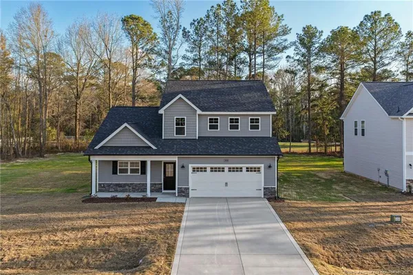 a view of a house with a yard and potted plants