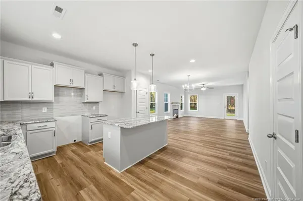 a large kitchen with kitchen island a sink stainless steel appliances and cabinets