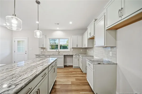 a kitchen with stainless steel appliances granite countertop sink stove and cabinets