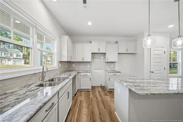 a kitchen with a sink stove and cabinets
