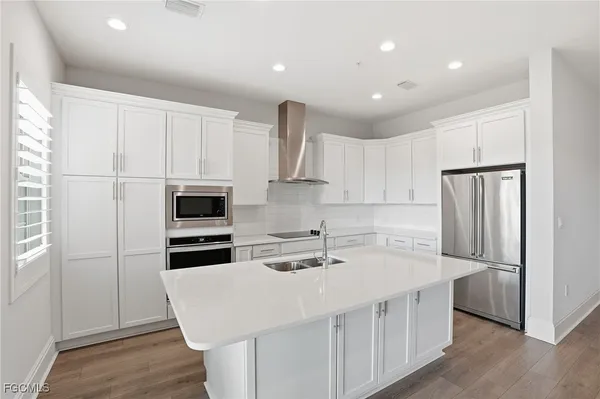 a kitchen with kitchen island a sink stainless steel appliances and refrigerator
