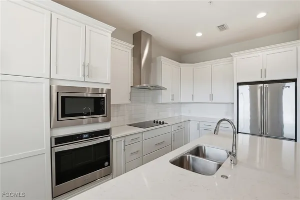 a kitchen with stainless steel appliances granite countertop a stove a sink and a microwave